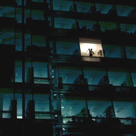 Illegale Überstunden: Ein Arbeitnehmer alleine im dunklen Bürokomplex