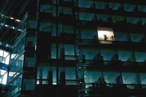 Illegale Überstunden: Ein Arbeitnehmer alleine im dunklen Bürokomplex