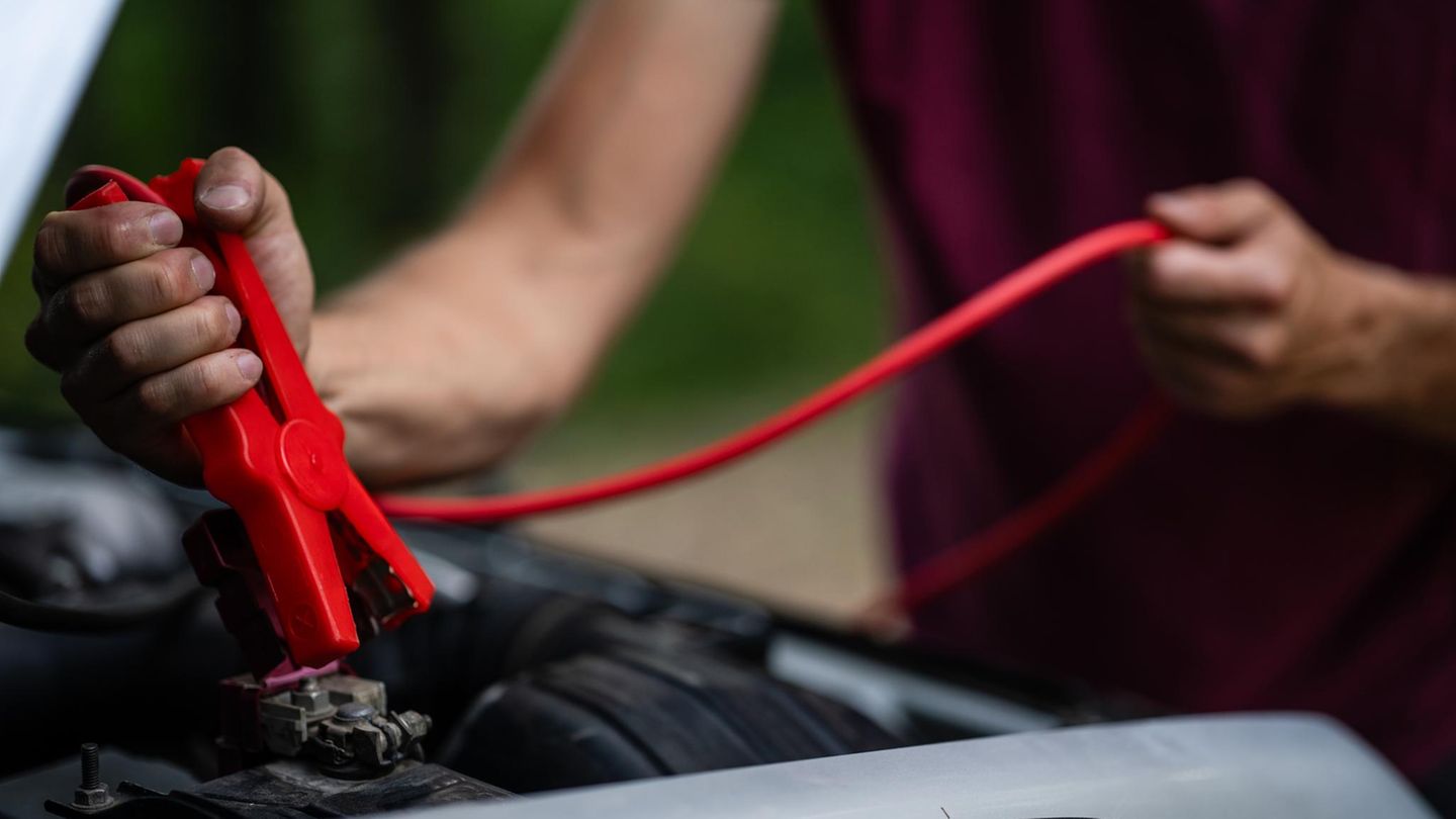 Person nutzt Starthilfe fürs Auto