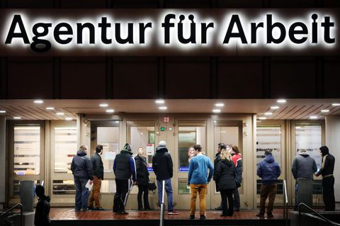 Arbeitssuchende stehen in Duisburg vor der Bundesagentur für Arbeit