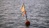 Eine Boje im Meer mit Fahne