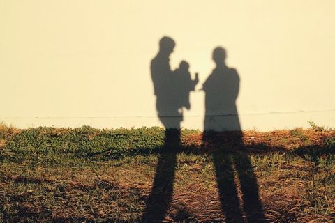 Erziehungsratgeber: Ein Elternpaar mit Baby als Schattenriss