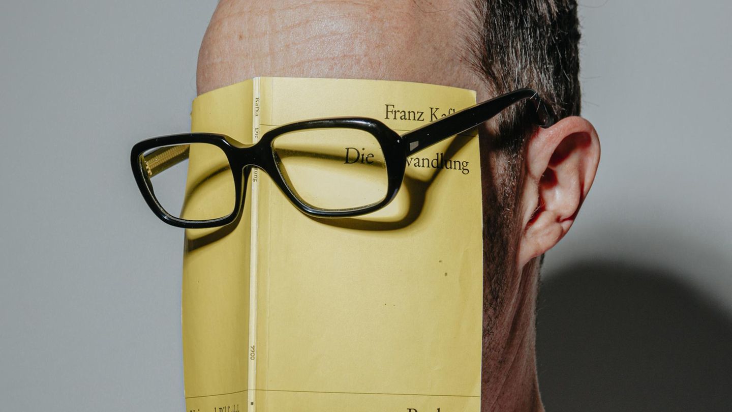Ein Mann trägt die Reclam-Ausgabe von Kafkas "Verwandlung" unter einer Brille