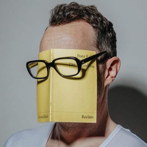 Ein Mann trägt die Reclam-Ausgabe von Kafkas "Verwandlung" unter einer Brille