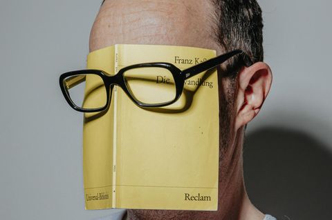Ein Mann trägt die Reclam-Ausgabe von Kafkas "Verwandlung" unter einer Brille