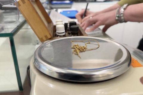 Eine Goldkette auf einer Waage