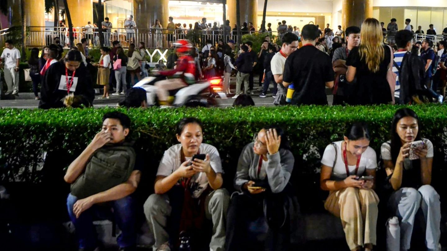 Menschen vor einem evakuierten Bürogebäude in Cebu