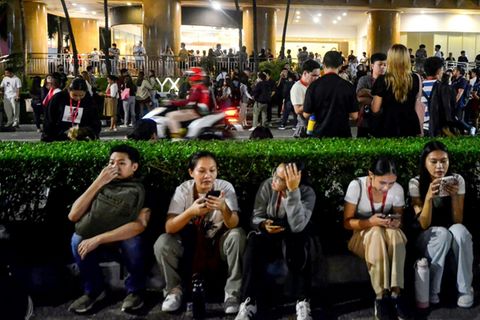 Menschen vor einem evakuierten Bürogebäude in Cebu