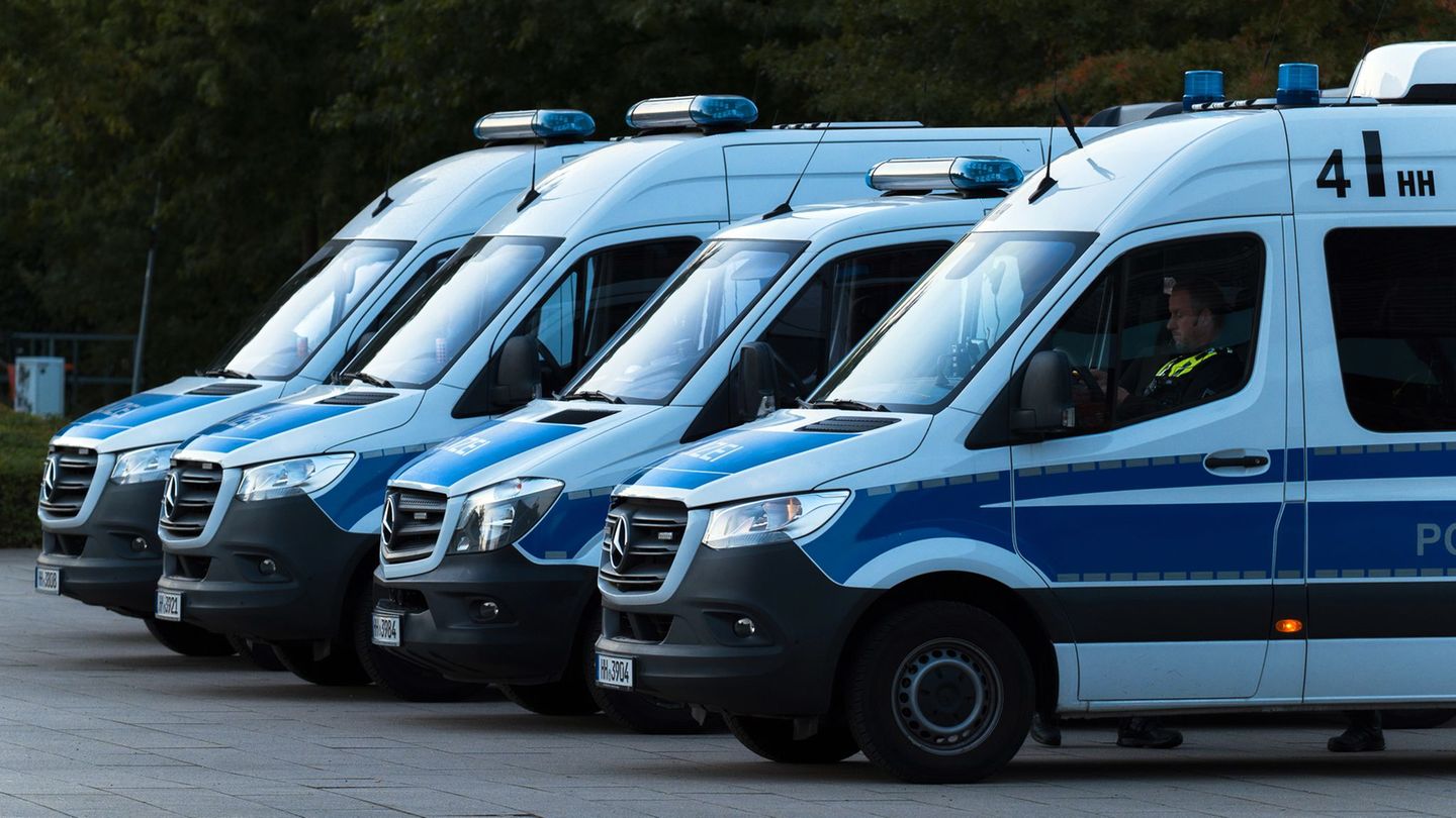 Einsatzfahrzeuge der Polizei stehen vor der Arena. Foto: Marcus Golejewski/dpa
