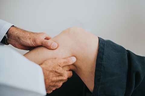 Arthritis: Arzt untersucht das Knie eines Patienten