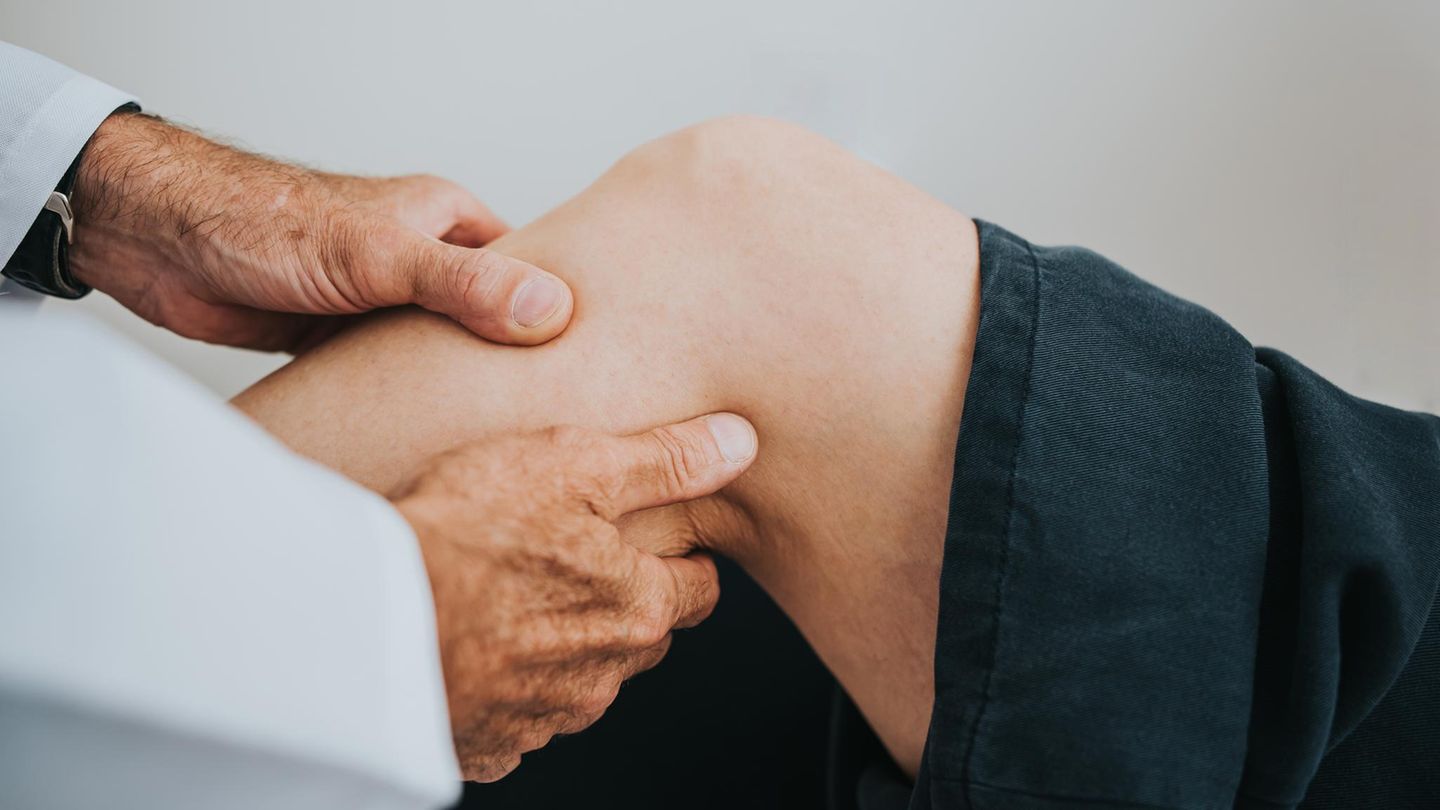 Arthritis: Arzt untersucht das Knie eines Patienten