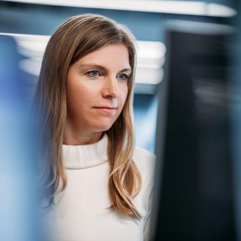 Eine IT-Fachfrau sitzt vor den Monitoren