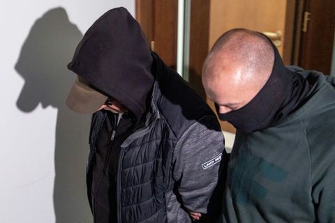 Polizist mit dem festgenomenen Wolodymyr Z. (l.) vor Gericht