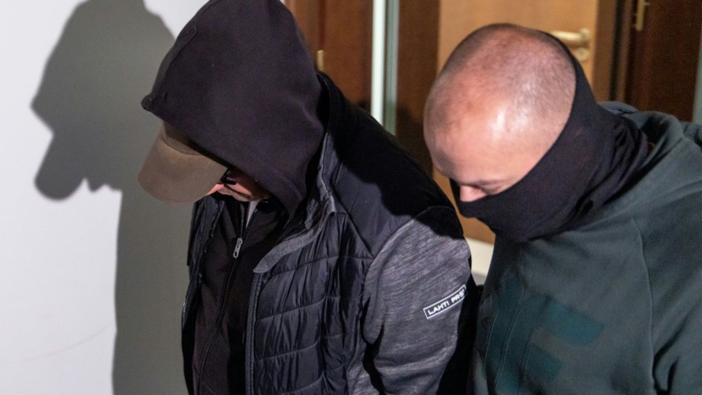 Polizist mit dem festgenomenen Wolodymyr Z. (l.) vor Gericht