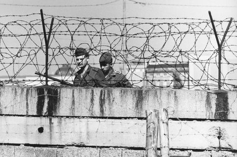 Zwei Grenzsoldaten hinter einer Mauer