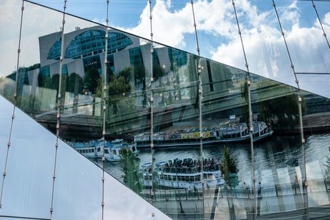 Spree und Kanzleramt spiegeln sich in Berliner Gebäude