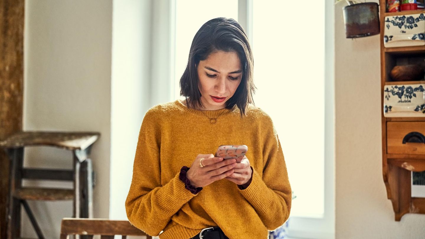 Eine Frau nutzt ihr Smartphone. Chattet sie bei Whatsapp?