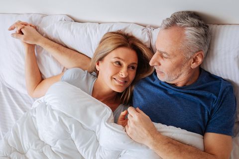 Ein älteres Paar liegt im Bett (Symbolbild Vasektomie)