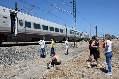 Passagiere neben einem liegen gebliebenen Zug am 28. April