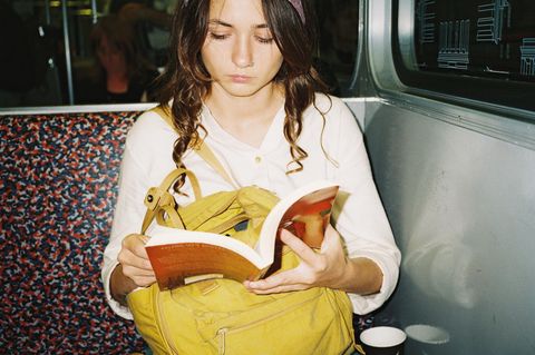 ein Mädchen liest in der Bahn
