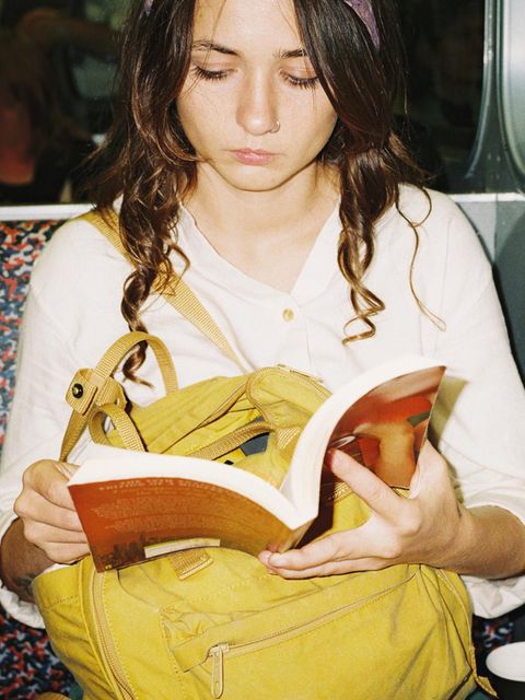 ein Mädchen liest in der Bahn