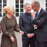 Das frische Paar feixt mit Kanzler Friedrich Merz