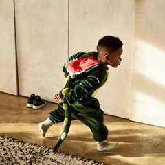 Ein Junge rennt im Dinokostüm durch das Zimmer