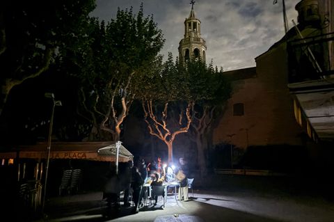 Während des Blackouts sitzen Gäste eines Straßencafés in der Kleinstadt Premià de Mar bei Barcelona im Licht von Taschenlampen u