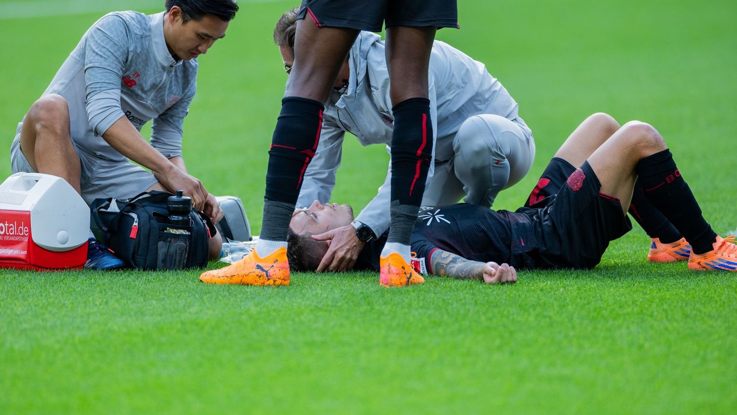 Bayer Leverkusens Kapitän Alejandro Grimaldo liegt nach einem Zusammenprall auf dem Boden. Foto: Rolf Vennenbernd/dpa