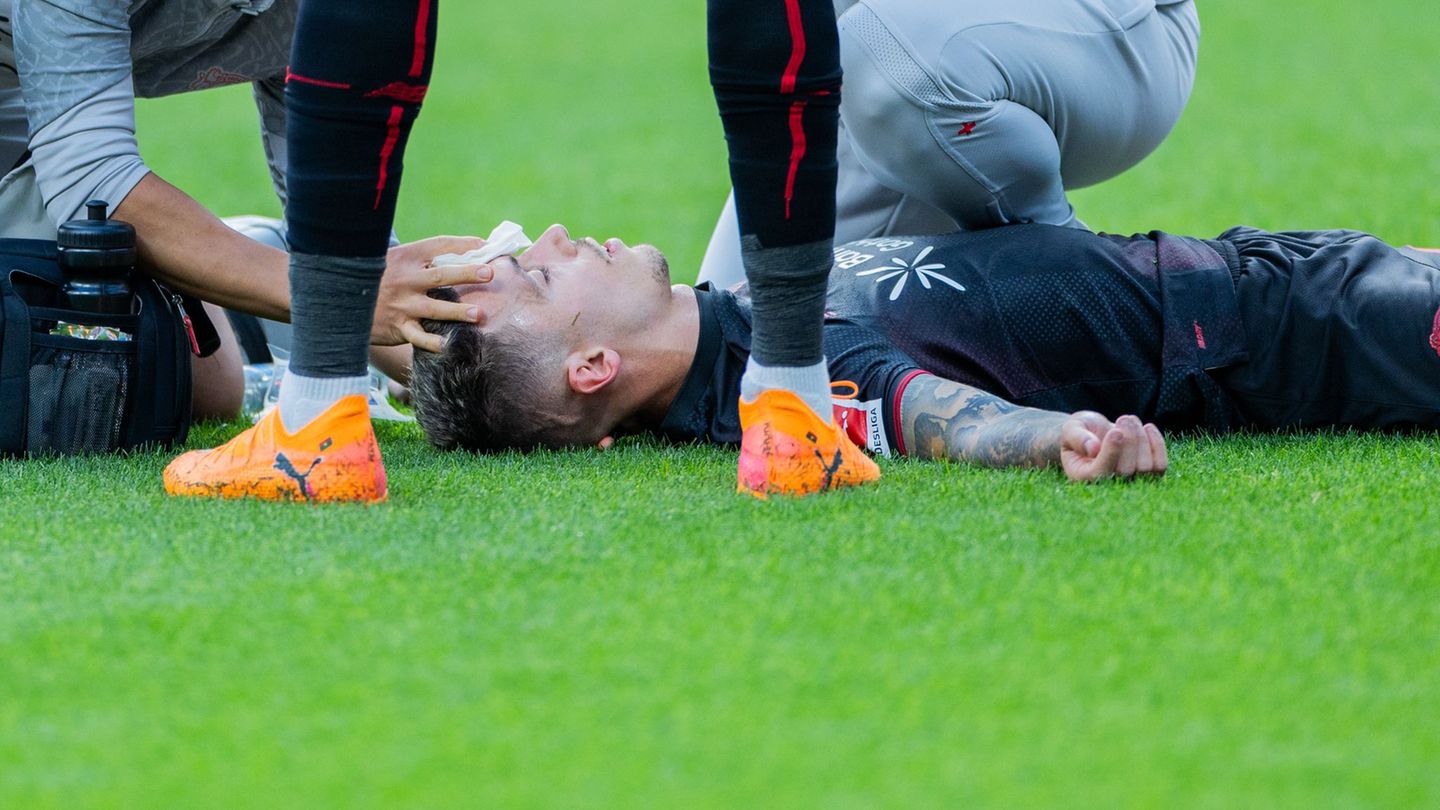 Bayer Leverkusens Kapitän Alejandro Grimaldo liegt nach einem Zusammenprall auf dem Boden. Foto: Rolf Vennenbernd/dpa