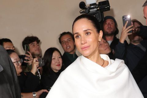 Herzogin Meghan in einem weißen Oberteil, Cape und Hose in Paris