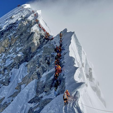 Am Mount Everest gehen ein Bergsteiger nach dem anderen einen Grat entlang