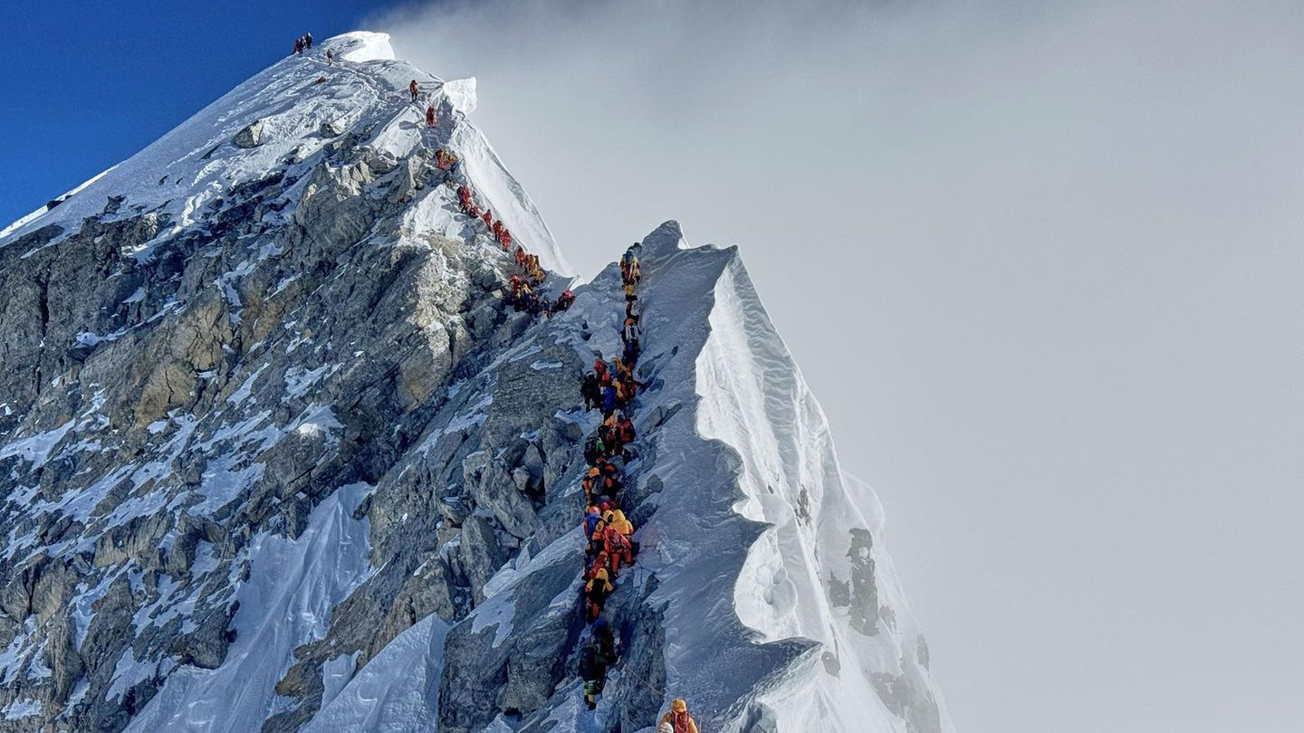 Am Mount Everest gehen ein Bergsteiger nach dem anderen einen Grat entlang