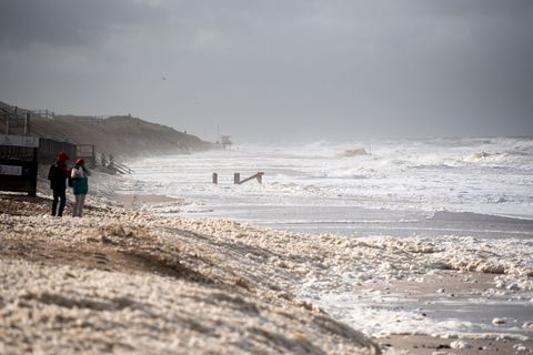 Sturmflut vor Sylt. Das Wetter lockte auch Spaziergänger an die Nordsee. Foto: Daniel Bockwoldt/dpa