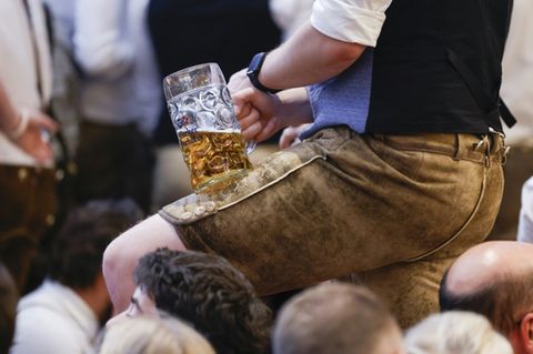 Oktoberfestbesucher in Lederhosen und mit Bierglas