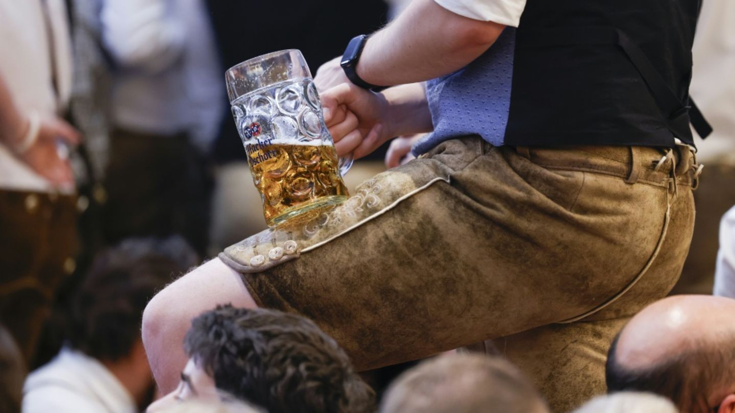 Oktoberfestbesucher in Lederhosen und mit Bierglas