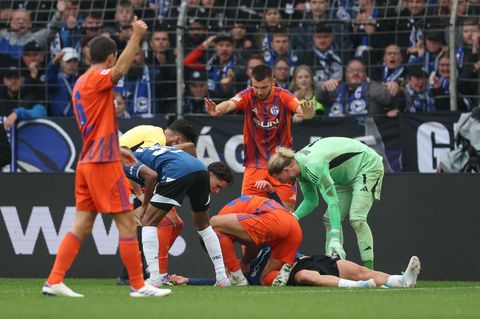 Joel Grodowski von Arminia Bielefeld liegt nach einem Zusammenprall auf dem Rasen