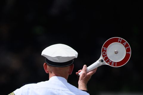 Ein Polizist winkt mit einer Kelle Fahrzeuge an die Seite