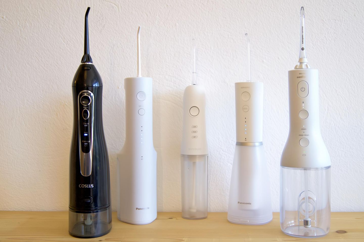 Fünf Mundduschen stehen auf einem Holztisch