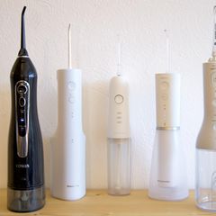 Fünf Mundduschen stehen auf einem Holztisch