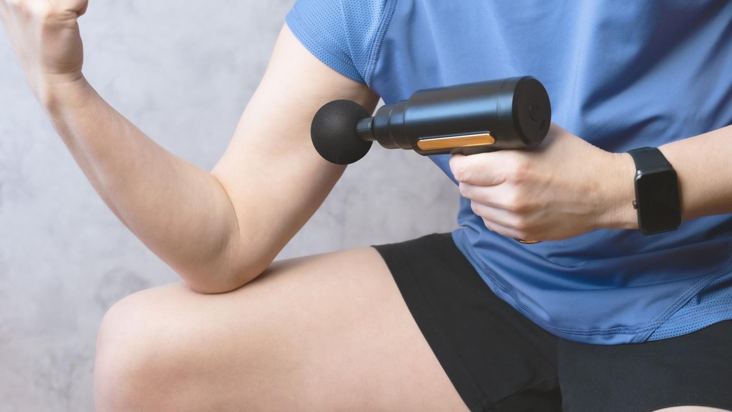 Deals des Tages: Frau in Sportoutfit mit Mini-Massagepistole
