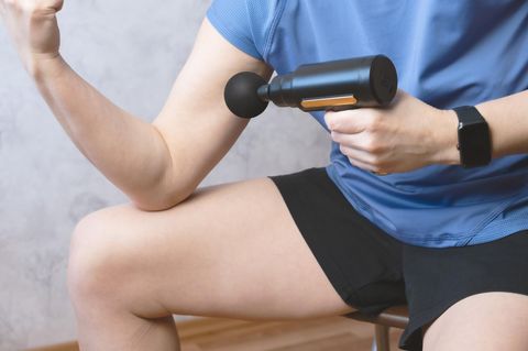 Deals des Tages: Frau in Sportoutfit mit Mini-Massagepistole