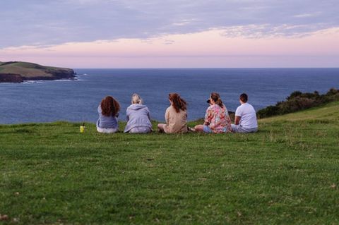 Eine Gruppe Touristen sitzt im Küstenort Gerringong in Australien an einem Aussichtspunkt