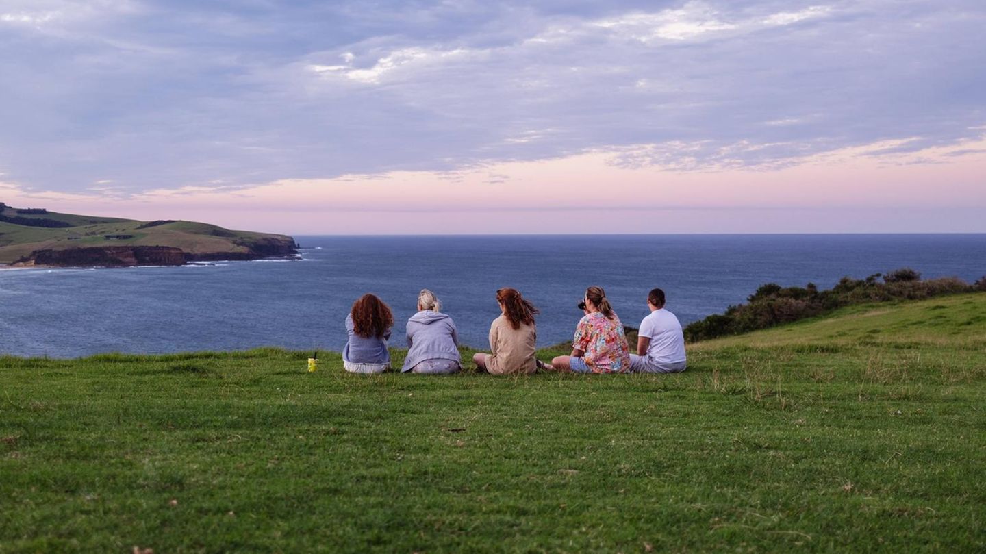 Eine Gruppe Touristen sitzt im Küstenort Gerringong in Australien an einem Aussichtspunkt