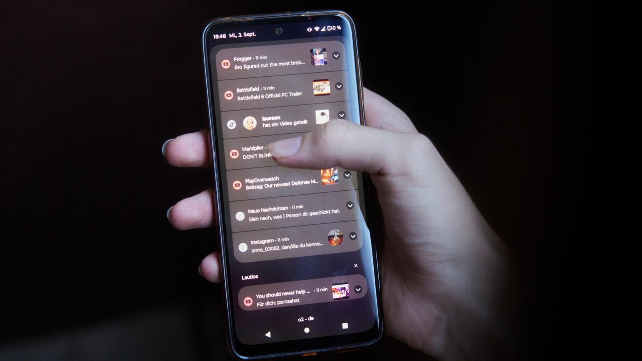 Handysucht: Eine Hand hält ein Smartphone in der Hand mit vielen Pop-Up Benachrichtigungen