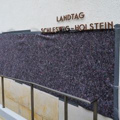 Angestellte eines Malerbetriebs haben Schriftzüge am Kieler Landtag verdeckt