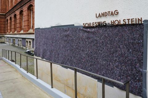 Angestellte eines Malerbetriebs haben Schriftzüge am Kieler Landtag verdeckt