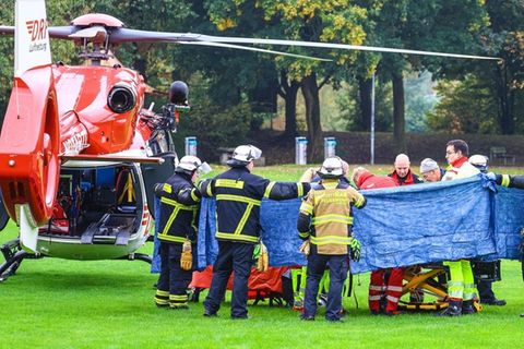 Einsatzkräfte in Herdecke stehen neben einem Rettungshubschrauber
