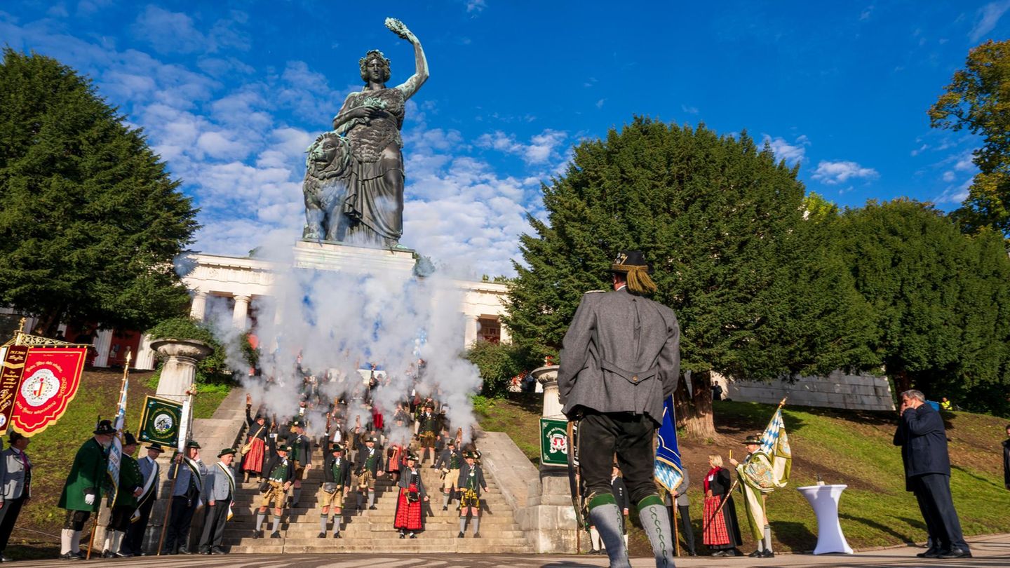 München, Deutschland. Im Schatten der monumentalen Bavaria, die seit 175 Jahren über die Theresienwiese wacht, feuern Böllerschützen Salven zum Jubiläumsfest ab. Markus Söder, der ansonsten auch ganz gern mal verbal losdonnert, ist das wohl zu laut – er hält sich mit etwas Abstand die Ohren zu
