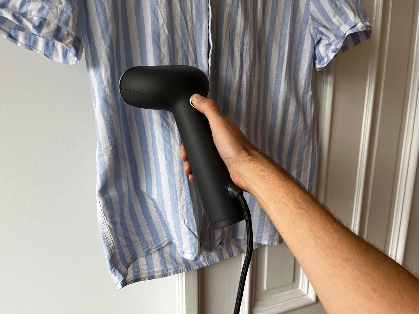 Ein Hemd wird mithilfe eines Steamers geglättet